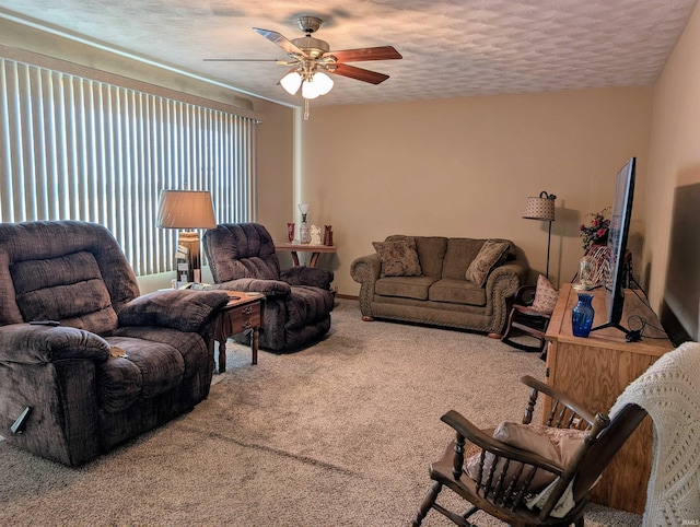 carpeted living room featuring ceiling fan and a textured ceiling