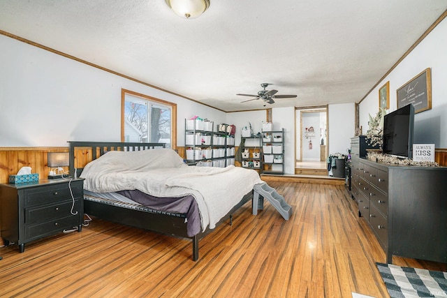 bedroom with crown molding, light hardwood / wood-style flooring, and a textured ceiling