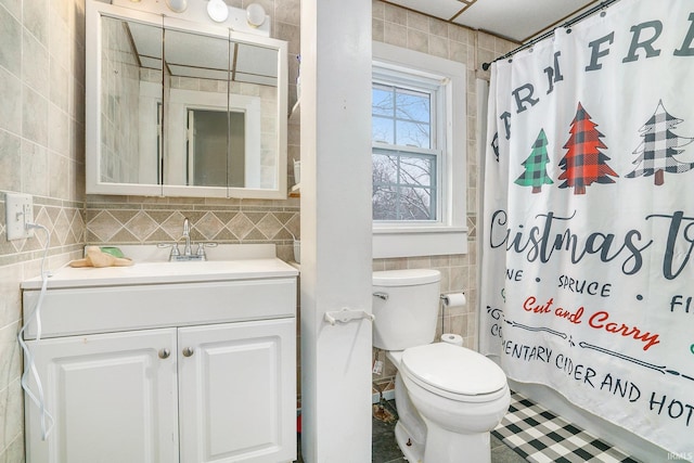 bathroom with tile walls, vanity, toilet, and a shower with shower curtain