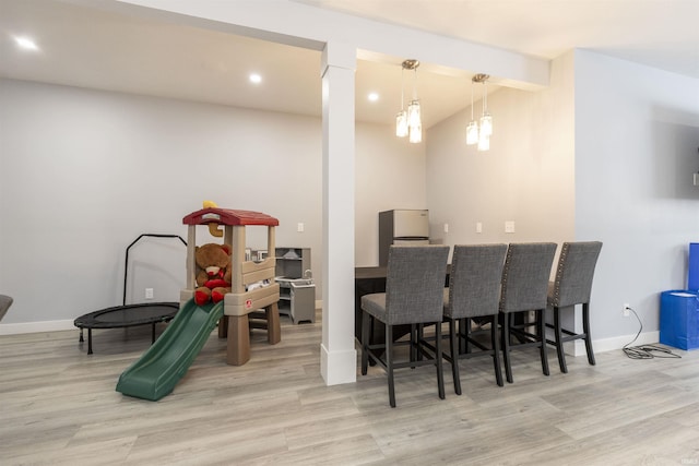 playroom with bar area and light hardwood / wood-style floors