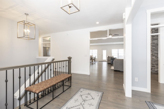 hallway with a notable chandelier and dark hardwood / wood-style floors