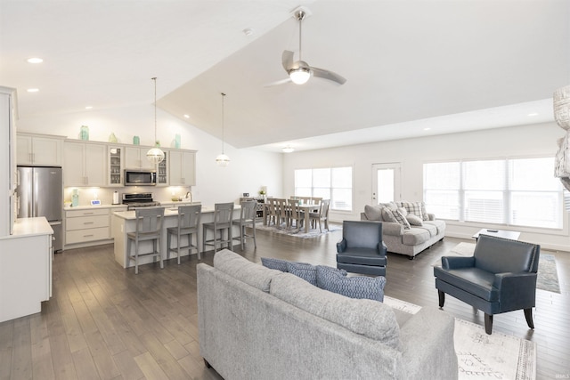 living room featuring ceiling fan, dark hardwood / wood-style flooring, and high vaulted ceiling