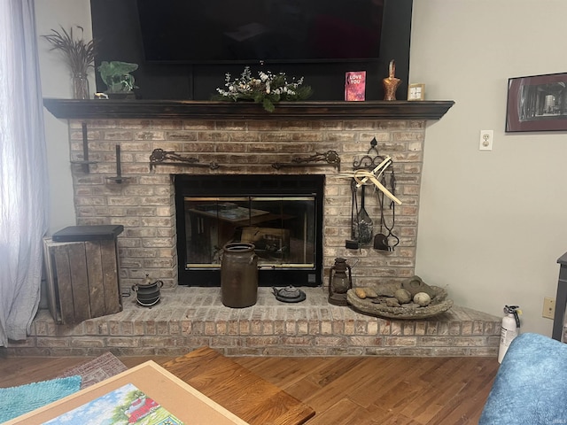 interior details featuring a fire extinguisher, a fireplace, and wood finished floors