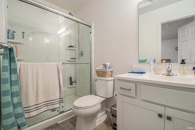 bathroom with vanity, hardwood / wood-style floors, an enclosed shower, and toilet