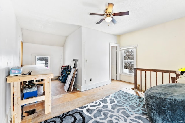 bedroom featuring ceiling fan, lofted ceiling, a textured ceiling, and light wood-type flooring