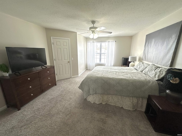 carpeted bedroom featuring ceiling fan and a textured ceiling