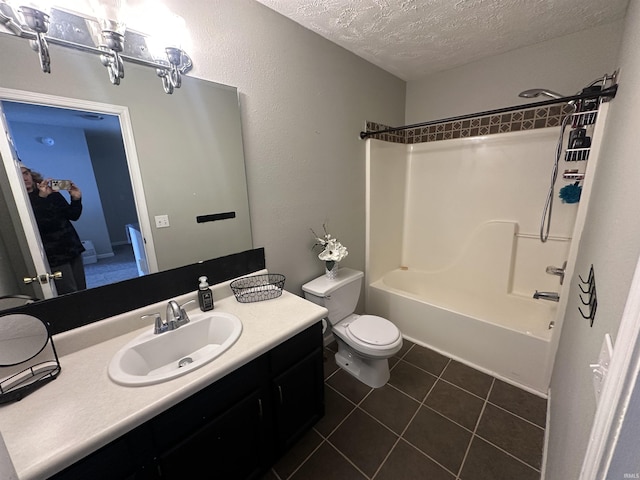 full bathroom featuring vanity, shower / bathing tub combination, a textured ceiling, tile patterned flooring, and toilet