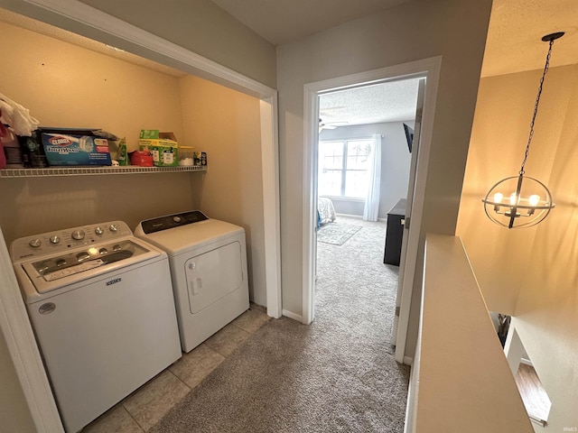 laundry area featuring washer and dryer, an inviting chandelier, light carpet, and a textured ceiling