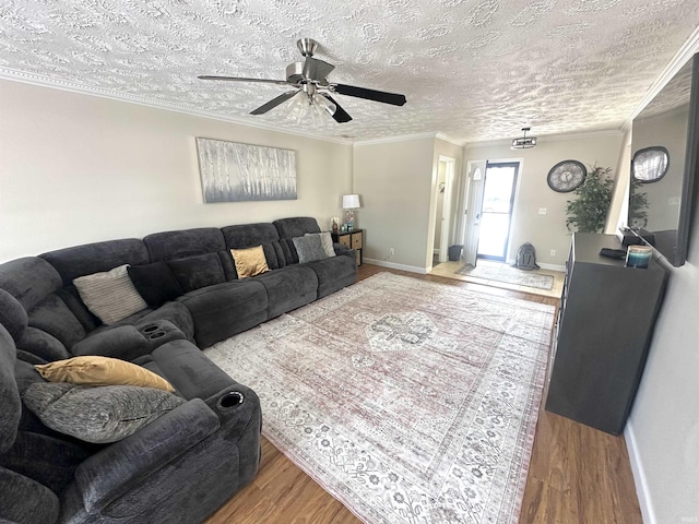 living room featuring a textured ceiling, crown molding, ceiling fan, and wood-type flooring