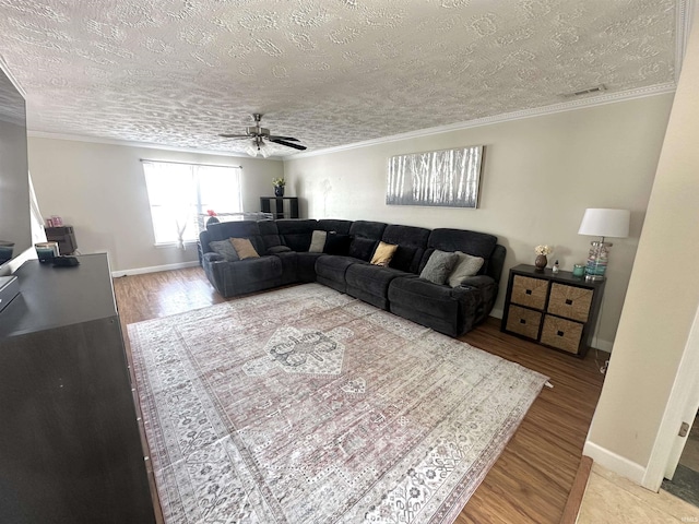 living room featuring a textured ceiling, ornamental molding, hardwood / wood-style floors, and ceiling fan