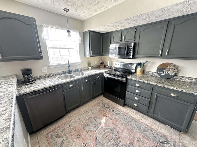 kitchen featuring appliances with stainless steel finishes, light stone counters, a textured ceiling, pendant lighting, and sink