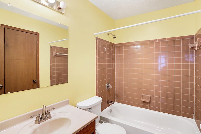 full bathroom featuring vanity, tiled shower / bath combo, and toilet