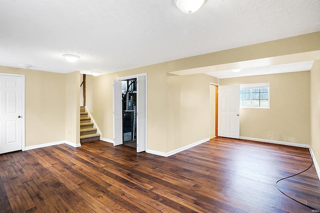 basement featuring dark wood-type flooring and a textured ceiling