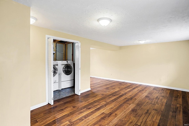 empty room with dark wood-type flooring, independent washer and dryer, and a textured ceiling