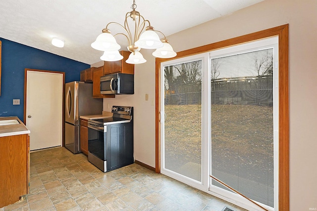 kitchen with lofted ceiling, sink, a chandelier, hanging light fixtures, and stainless steel appliances