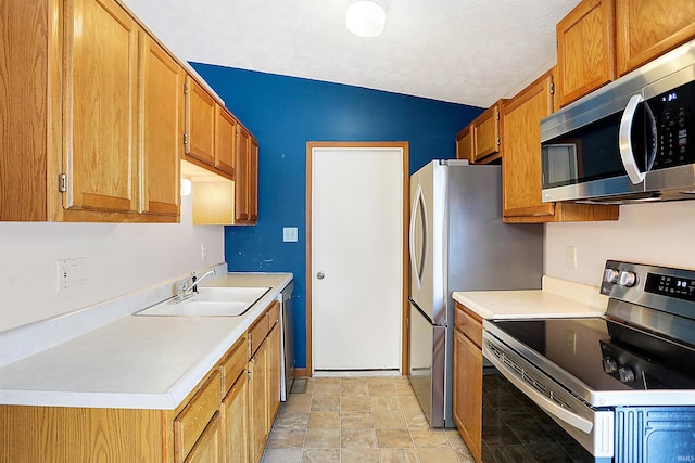 kitchen with stainless steel appliances, sink, and a textured ceiling