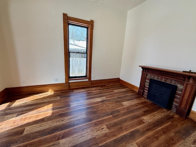 unfurnished living room with a fireplace, wood finished floors, and baseboards