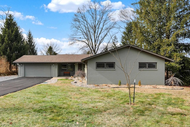 ranch-style home featuring a garage and a front lawn