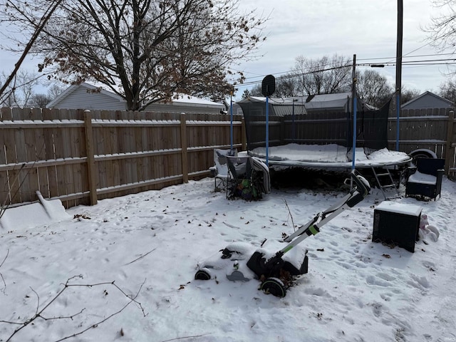 yard covered in snow with a trampoline