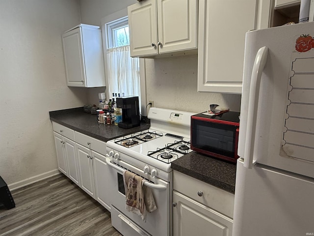 kitchen with dark wood-type flooring, white appliances, and white cabinets