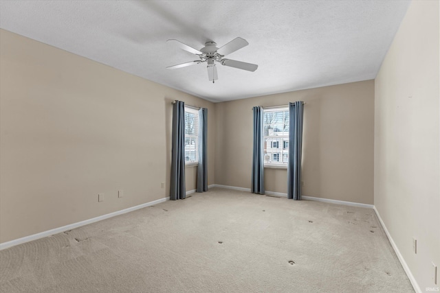 carpeted spare room featuring ceiling fan and a textured ceiling