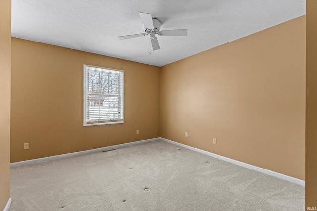 unfurnished room featuring a textured ceiling, ceiling fan, and light colored carpet