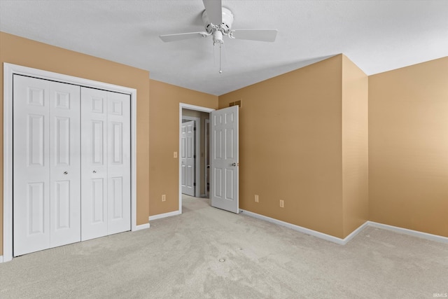 unfurnished bedroom featuring light carpet, a closet, and ceiling fan