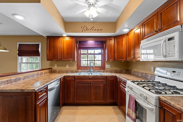 kitchen with white appliances, ceiling fan, light tile patterned floors, sink, and kitchen peninsula