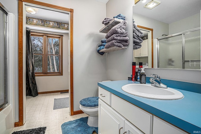 full bathroom featuring enclosed tub / shower combo, vanity, and toilet
