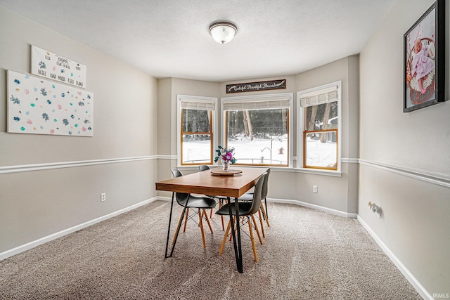 carpeted dining area featuring a textured ceiling