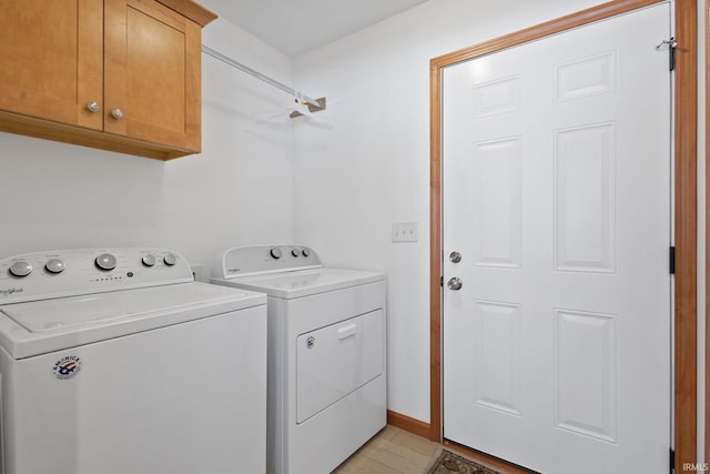 laundry room featuring washer and clothes dryer and cabinets