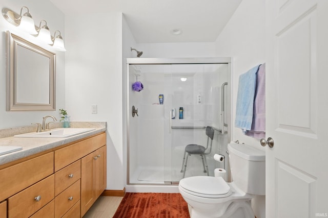 bathroom with toilet, a shower with door, and vanity