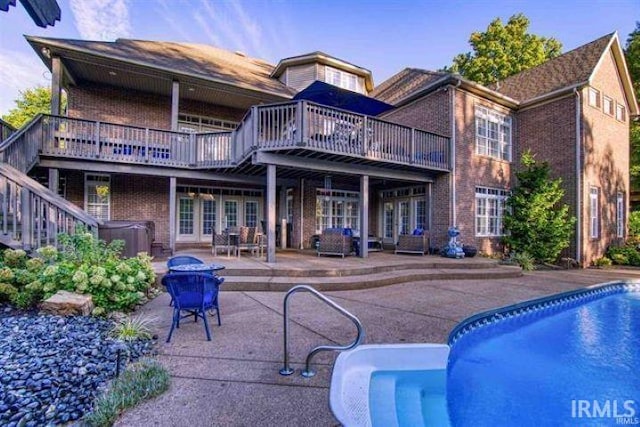 back of house featuring a patio area and a swimming pool with hot tub