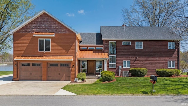 view of front of house with a front yard, a garage, and central air condition unit