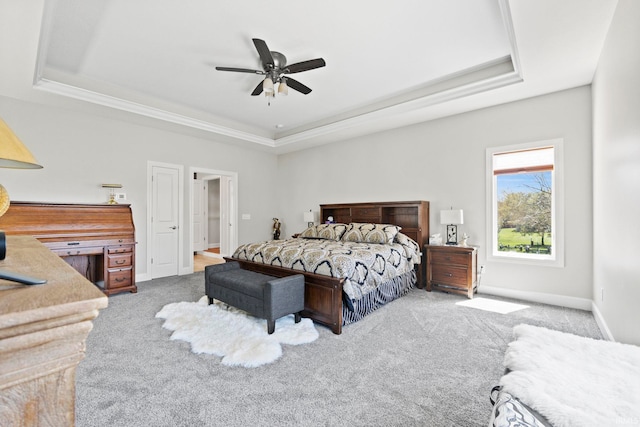 carpeted bedroom featuring ceiling fan and a raised ceiling