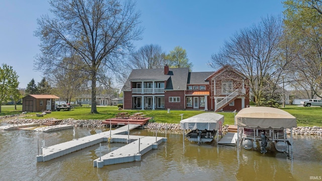 view of dock featuring a water view, a balcony, and a lawn