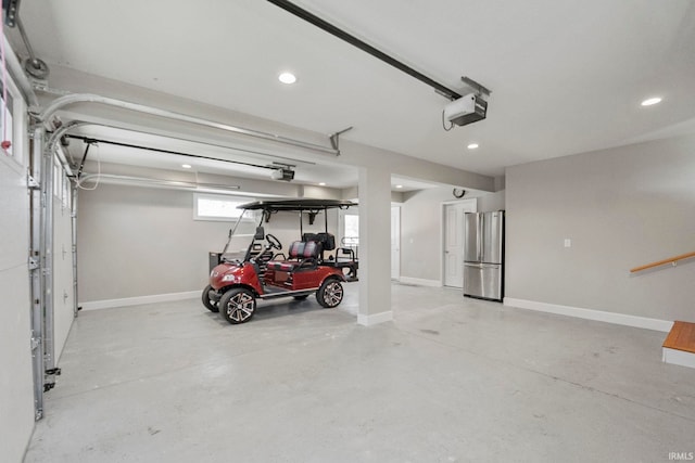 garage with a garage door opener and stainless steel refrigerator