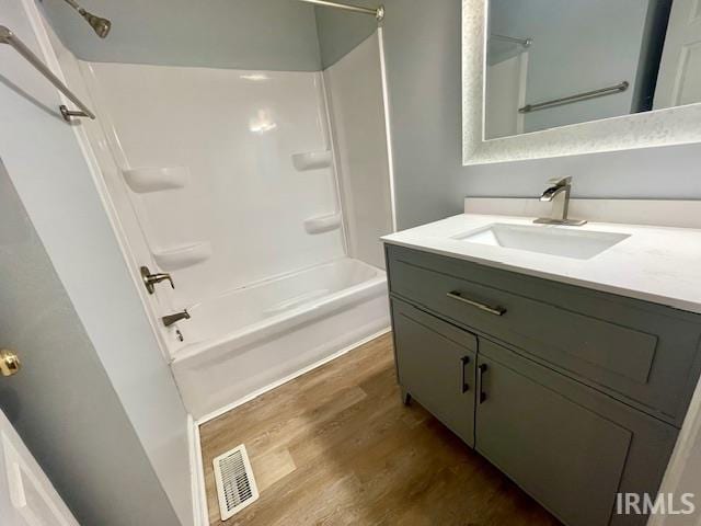 bathroom featuring hardwood / wood-style floors, vanity, and shower / washtub combination