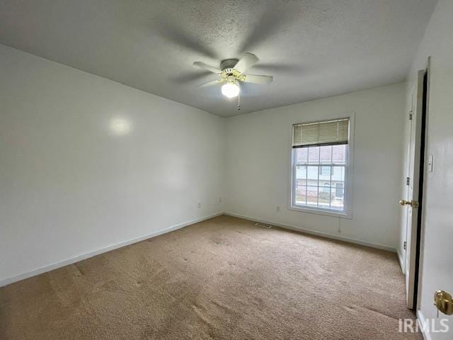 carpeted empty room with a textured ceiling and ceiling fan