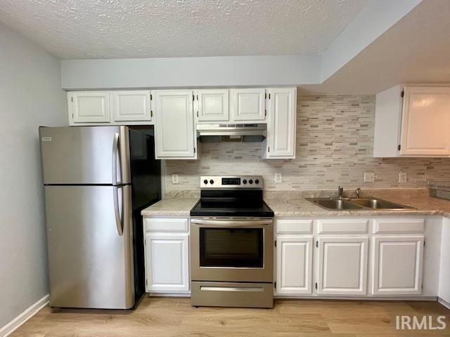 kitchen featuring sink, backsplash, white cabinets, and stainless steel appliances