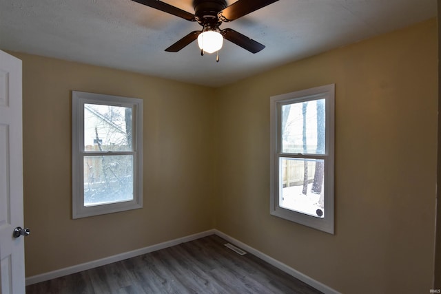 spare room with ceiling fan, dark hardwood / wood-style flooring, and plenty of natural light