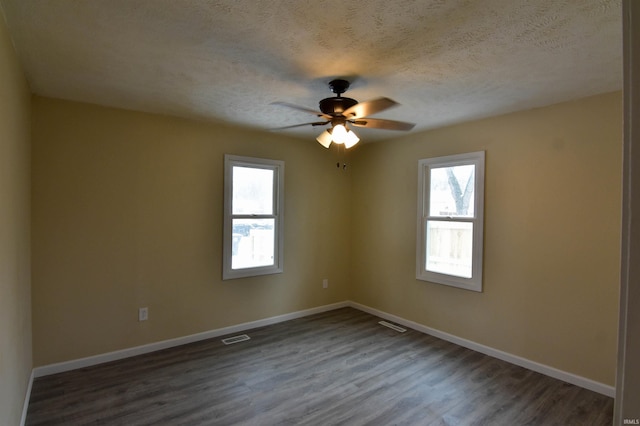 spare room featuring ceiling fan, dark hardwood / wood-style floors, and a textured ceiling