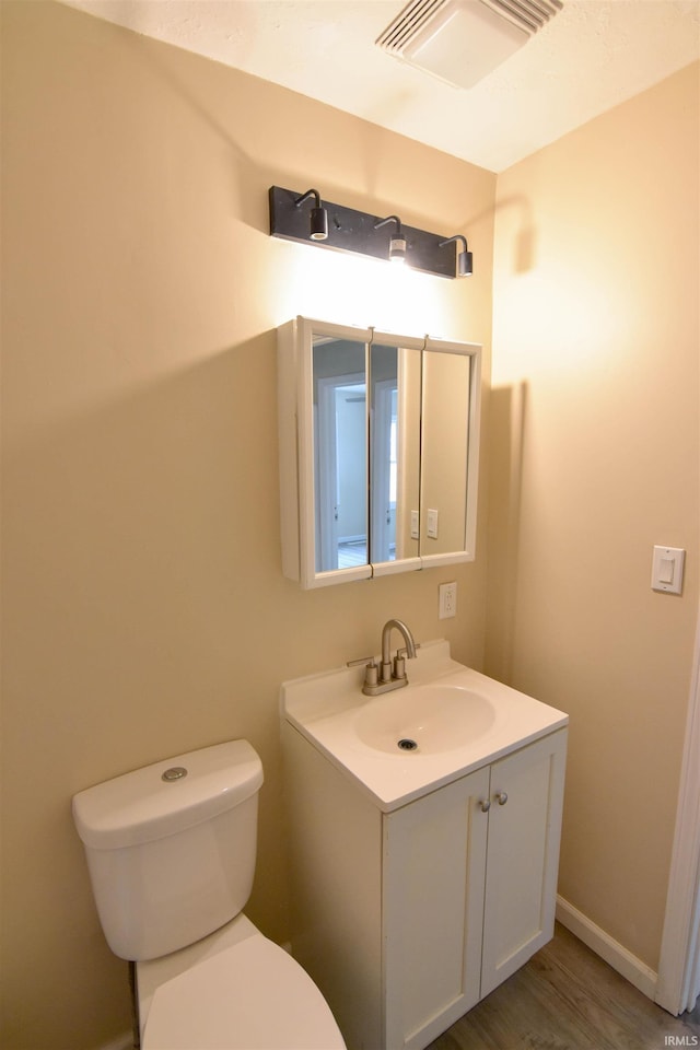 bathroom featuring hardwood / wood-style floors, toilet, and vanity