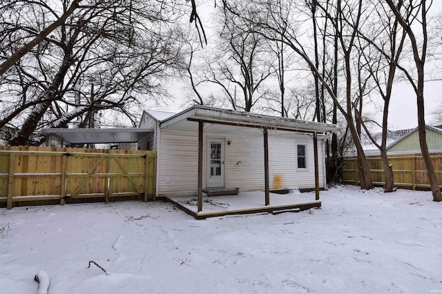 view of snow covered rear of property