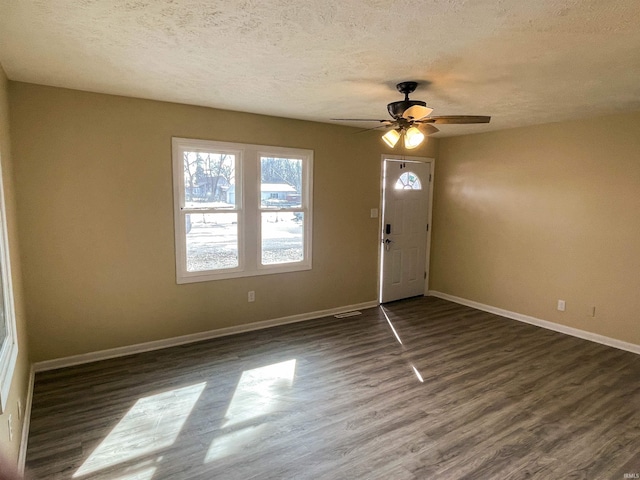 foyer entrance featuring dark hardwood / wood-style flooring, ceiling fan, and a textured ceiling