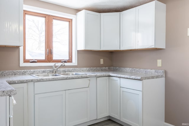 kitchen featuring white cabinetry and sink