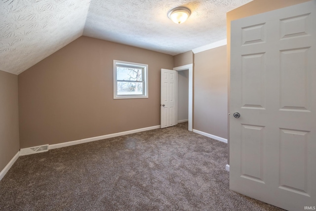 additional living space featuring carpet, lofted ceiling, and a textured ceiling