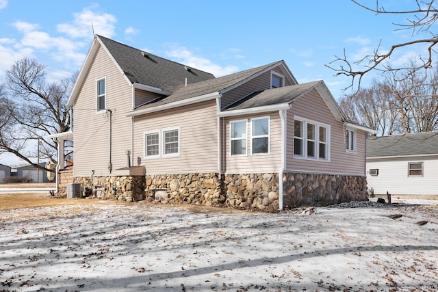 snow covered property featuring central AC