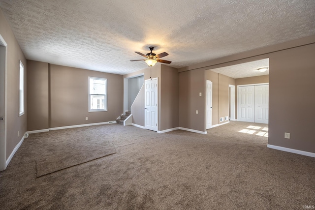 unfurnished room featuring carpet, ceiling fan, and a textured ceiling