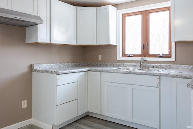 kitchen with sink, white cabinetry, and hardwood / wood-style floors